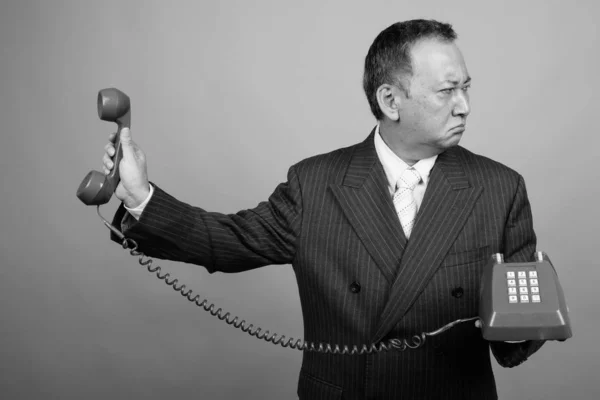 Studio Shot Mature Asian Businessman Using Old Telephone Gray Background — Photo