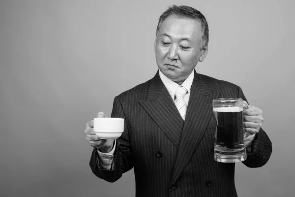 Studio Shot Mature Asian Businessman Holding Coffee Cup Glass Beer — Stockfoto