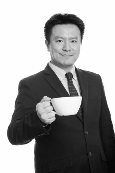Studio shot van Japanse zakenman holding koffiekopje — Stockfoto