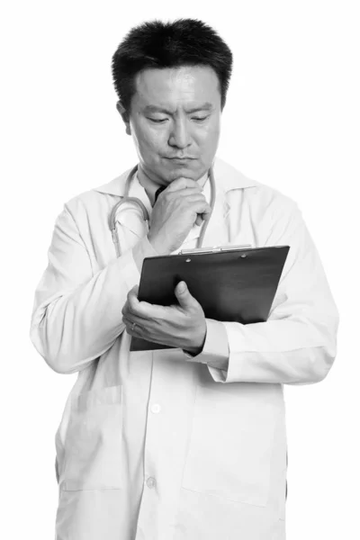 Japanese man doctor reading on clipboard while thinking — Stock Photo, Image