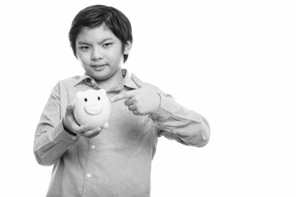 Studio záběr roztomilé japonské chlapce drží prasátko a ukazoval prstem — Stock fotografie