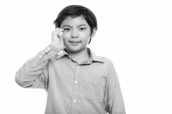 Estúdio tiro de menino japonês feliz sorrindo enquanto fala no telefone celular — Fotografia de Stock