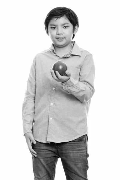 Estúdio tiro de menino japonês bonito de pé enquanto segurando maçã vermelha — Fotografia de Stock