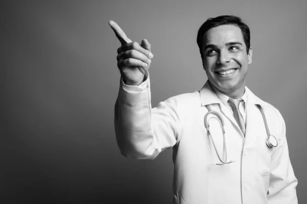 スタジオショットのハンサムなペルシャ人医師に対してグレー背景で黒と白 — ストック写真