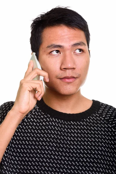 Beszél a mobil telefon, miközben gondolkodás ázsiai fiatalember arca — Stock Fotó