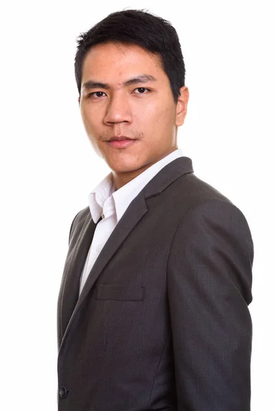 Profilo vista di giovane uomo d'affari asiatico in giacca e cravatta guardando la fotocamera — Foto Stock