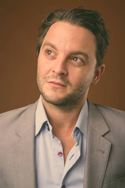 Studio shot of Italian businessman against brown background — Stock Photo, Image