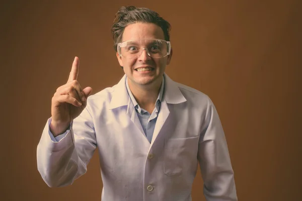 Olasz férfi orvos visel védő szemüveg ellen barna háttér — Stock Fotó