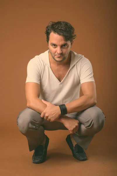 Studio shot of Italian man against brown background