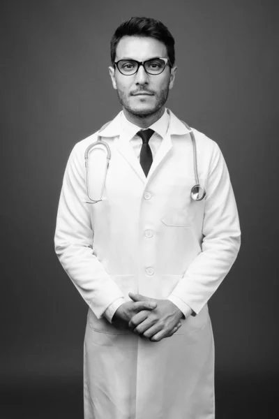 Estudio Joven Guapo Médico Hispano Con Anteojos Sobre Fondo Gris — Foto de Stock