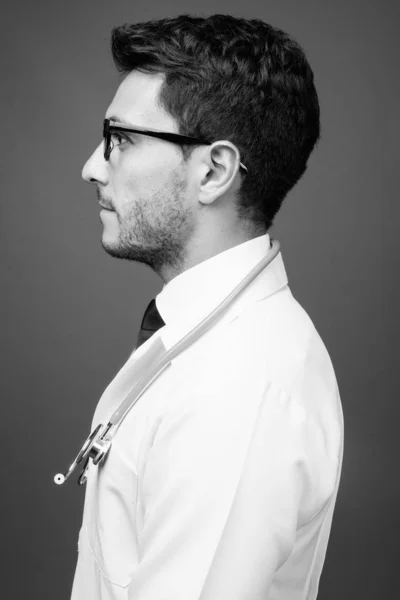 스튜디오에서 잘생긴 히스패닉 의사가 흑백으로 배경에 안경을 채찍은 — 스톡 사진