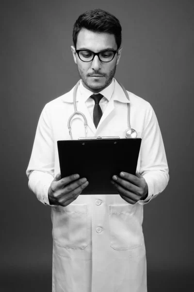 Estudio Joven Guapo Médico Hispano Con Anteojos Sobre Fondo Gris — Foto de Stock