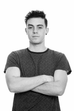 Kollarını kavuşturmuş genç bir adamın stüdyo fotoğrafı.