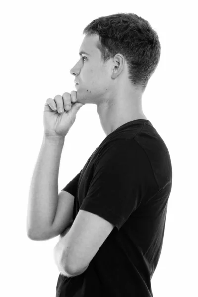 Profilbild eines jungen Mannes, der mit der Hand am Kinn denkt — Stockfoto