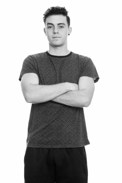 Studio ujęcie młodego człowieka stojącego z skrzyżowanymi ramionami — Zdjęcie stockowe