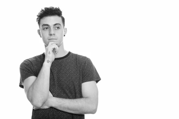 Studio shot of young man thinking while looking at distance — Stock Photo, Image