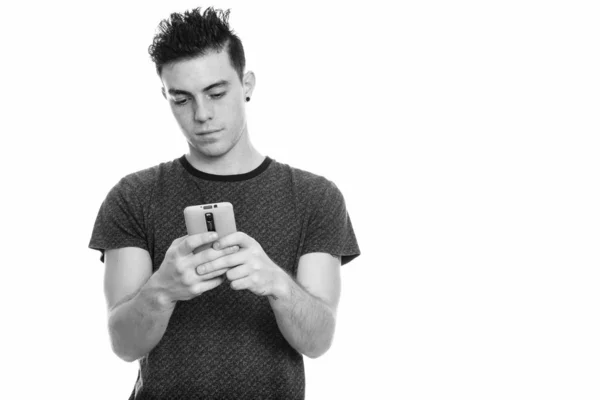 Studio shot of young man using mobile phone — Stock Photo, Image