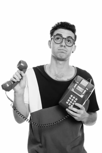 Studio shot van jonge man, oude telefoon te houden terwijl op zoek gestrest — Stockfoto