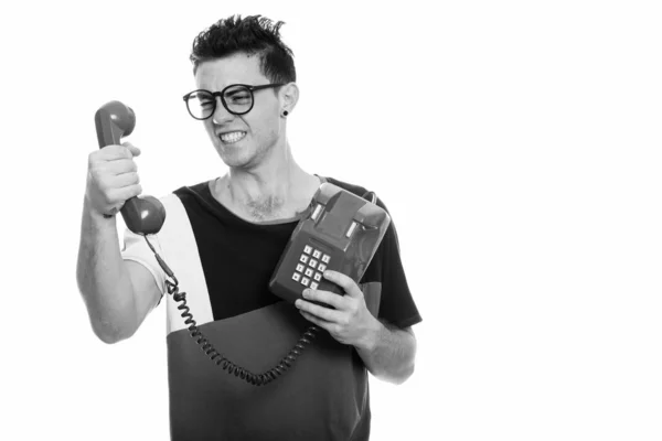 Irritado jovem segurando telefone velho em preto e branco — Fotografia de Stock