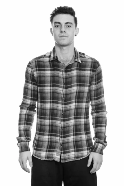 Студийный снимок молодого человека, стоящего в черно-белом — стоковое фото