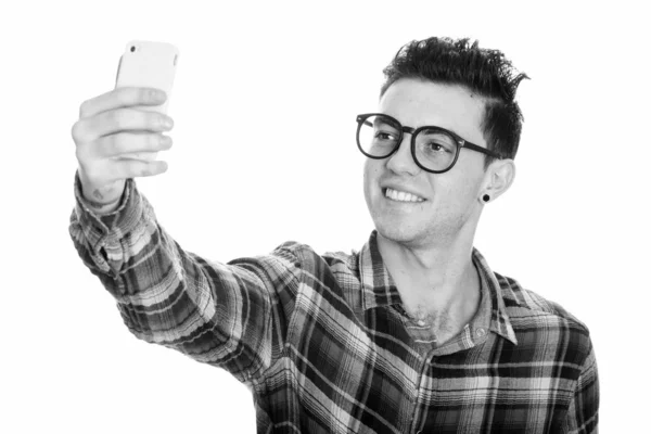 Estudio de tiro de joven feliz sonriendo mientras toma foto selfie con el teléfono móvil — Foto de Stock