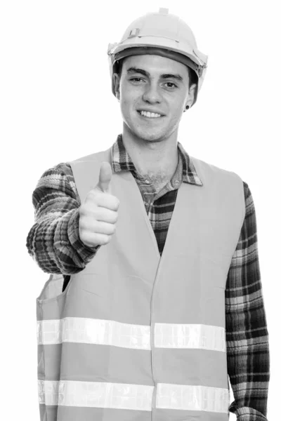 Studio shot van gelukkige jongeman bouwvakker glimlachen terwijl het geven van duim omhoog — Stockfoto