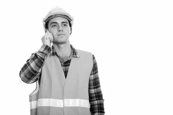 Thoughtful young man construction worker talking on mobile phone — 스톡 사진