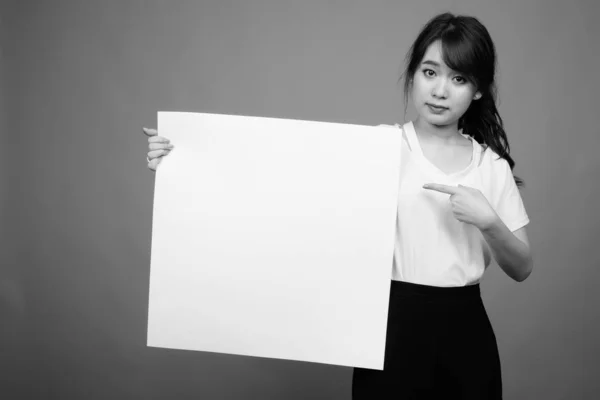 백인으로 구성된 배경에 반대하는 아름다운 아시아 여성의 스튜디오 — 스톡 사진