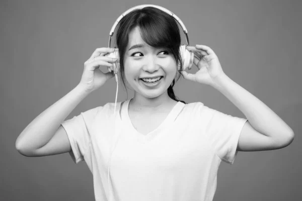 Estúdio Tiro Jovem Bela Mulher Asiática Ouvindo Música Contra Fundo — Fotografia de Stock