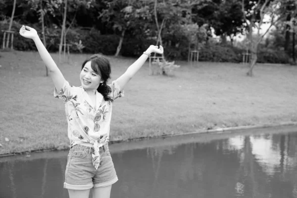 年轻美丽的亚洲女游客穿着黑白相间的衣服在公园里放松的画像 — 图库照片