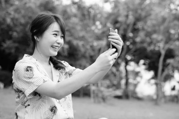Young beautiful Asian tourist woman relaxing at the park — 스톡 사진