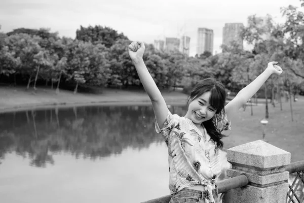 Νεαρή όμορφη Ασιάτισσα τουρίστρια χαλαρώνει στο πάρκο — Φωτογραφία Αρχείου
