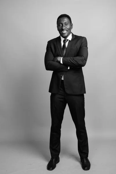 Jovem bonito empresário africano contra fundo cinza — Fotografia de Stock