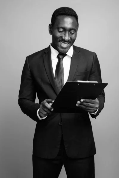 Jovem bonito empresário africano contra fundo cinza — Fotografia de Stock