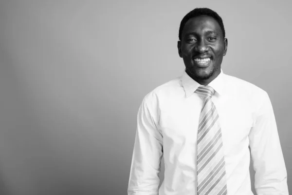 Ung stilig afrikansk affärsman mot grå bakgrund — Stockfoto