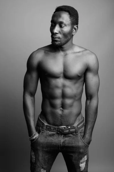 Молодой красивый африканский мужчина без рубашки на сером фоне — стоковое фото