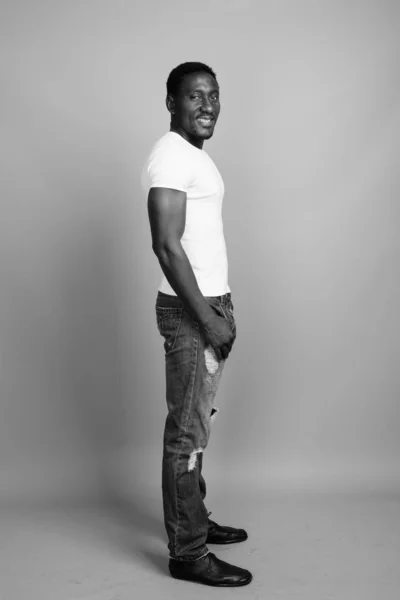 Junger gutaussehender afrikanischer Mann vor grauem Hintergrund — Stockfoto