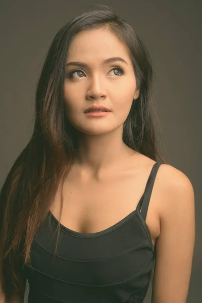 年轻美丽的亚洲妇女在灰色背景 — 图库照片