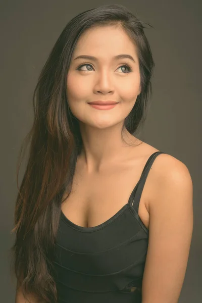 Joven hermosa mujer asiática contra fondo gris — Foto de Stock