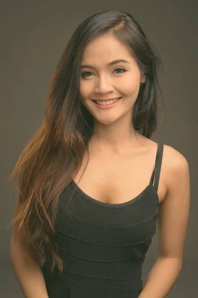 Νεαρή όμορφη γυναίκα της Ασίας γκρι φόντο — Φωτογραφία Αρχείου
