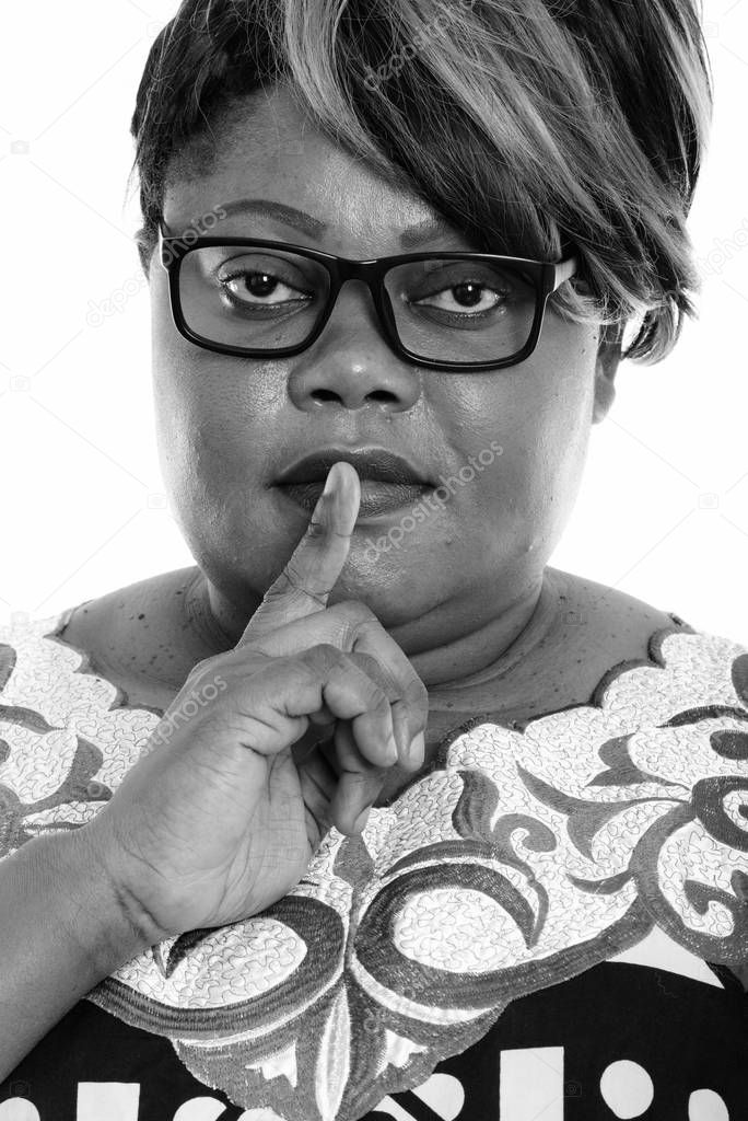 Studio shot of beautiful overweight African woman isolated against white background in black and white