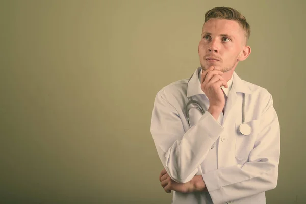 Portrait of young man doctor against colored background — 스톡 사진