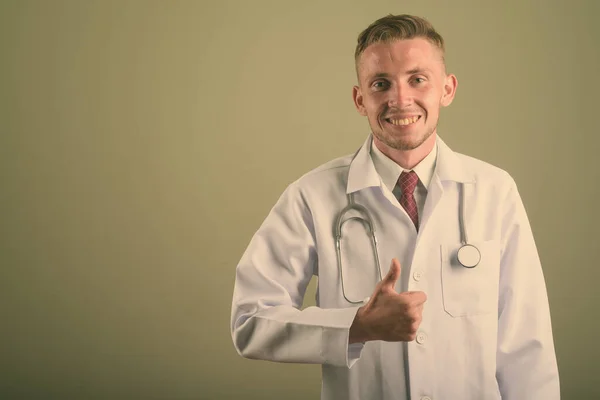 Portrait of young man doctor against colored background — 스톡 사진