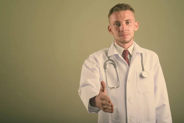 Retrato de joven médico sobre fondo de color — Foto de Stock