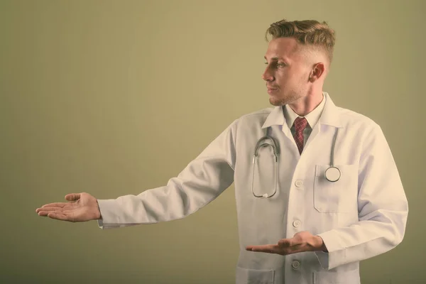 Portrait of young man doctor against colored background — 스톡 사진