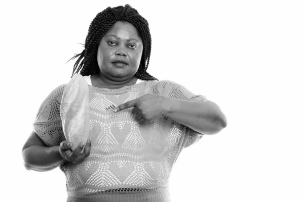 Studio záběr tlusté černošky africké ženy drží a ukazuje na chléb — Stock fotografie
