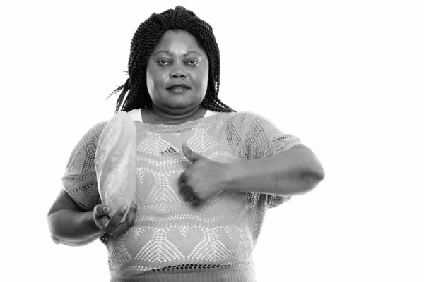 Studio záběr tlusté černošky africké ženy držící chléb a dávat palec nahoru — Stock fotografie