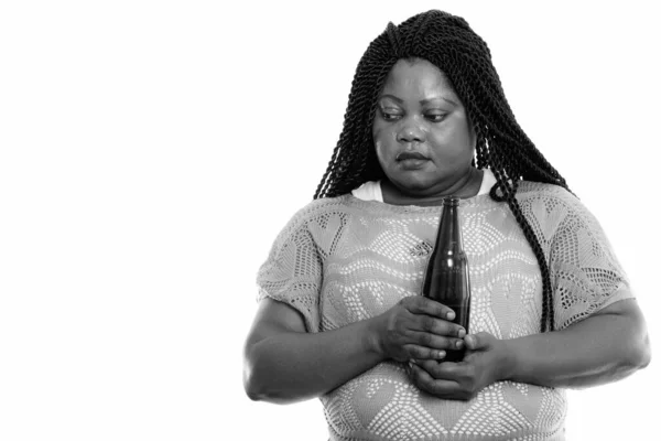 Studio záběr tlusté černošky africké ženy při pohledu smutné myšlení a držení láhve piva — Stock fotografie