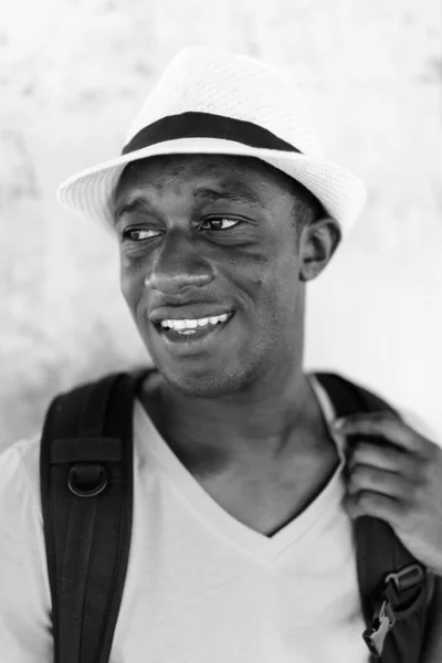 Rostro de joven feliz turista africano pensando contra muro de hormigón —  Fotos de Stock