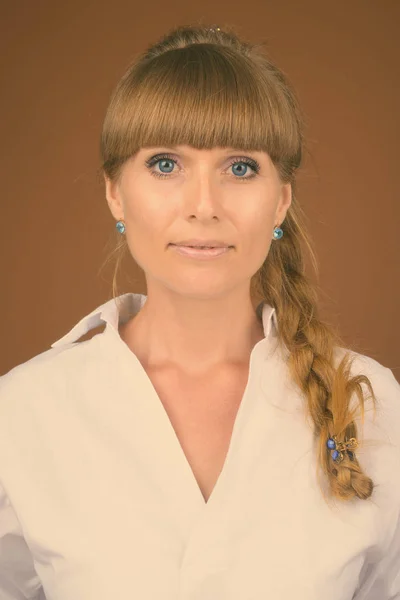 Портрет молодой красивой предпринимательницы на коричневом фоне — стоковое фото